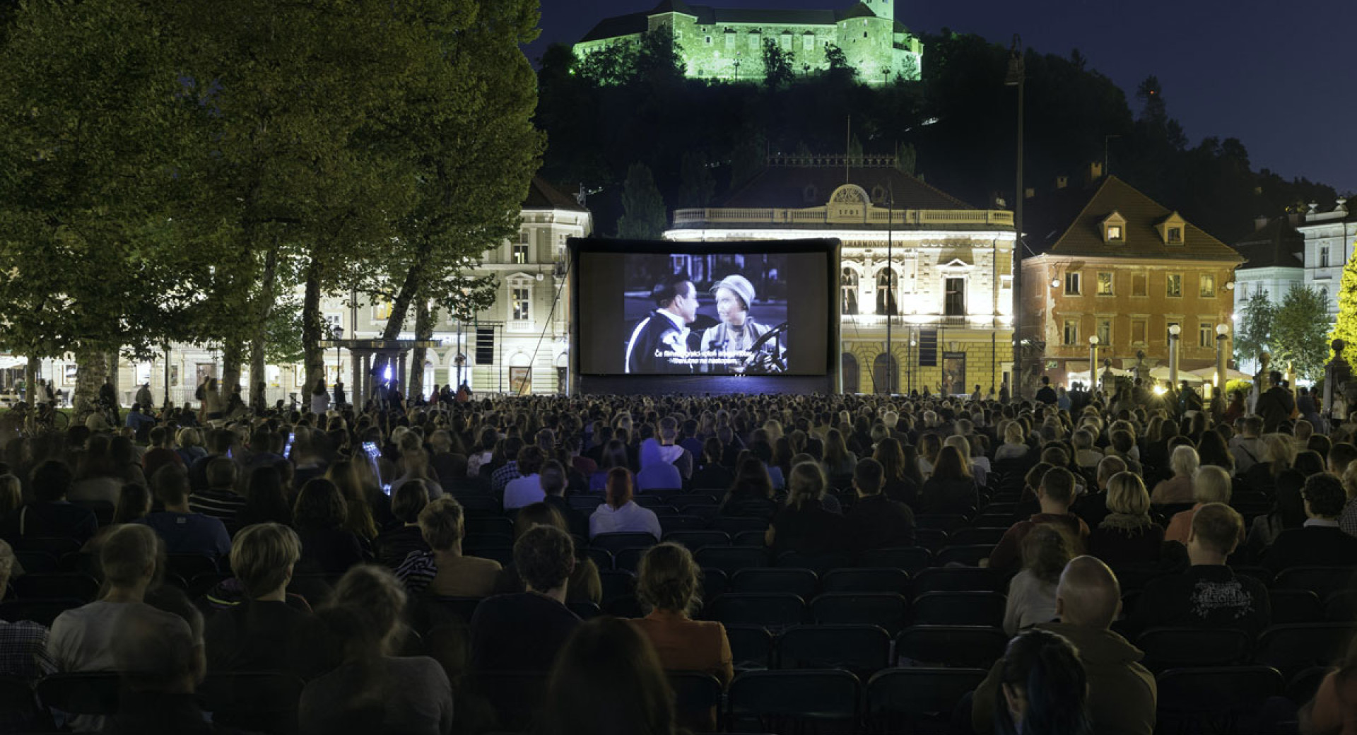 Film v kinu na prostem na Kongresnem trgu. V ozadju Ljubljanski grad.