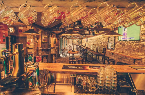Vista da dietro il bancone sull'interno accogliente del Cutty Sark Pub.