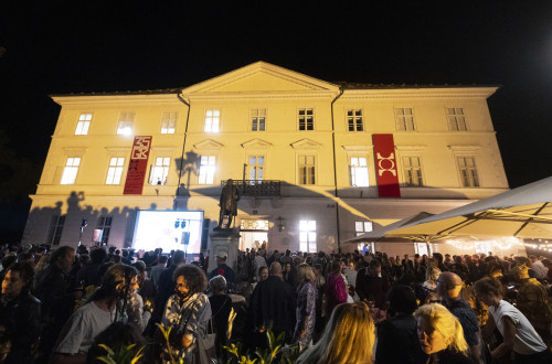 Zunanjost galerije z mnozico ljudi.