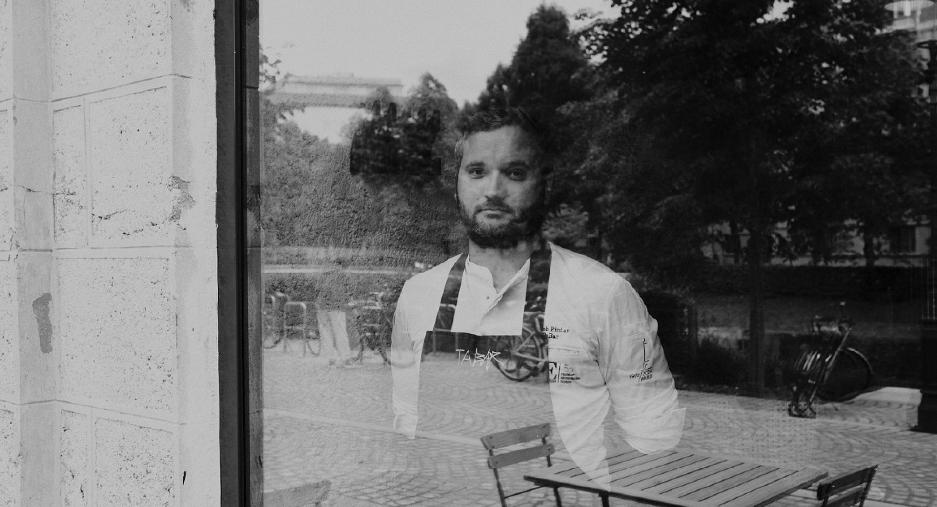 Crnobela fotografija moskega, ki zre skozi okno.