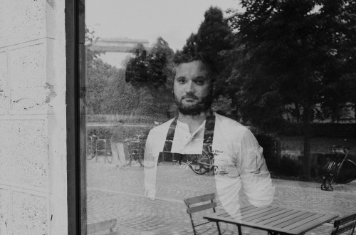 Crnobela fotografija moskega, ki zre skozi okno.
