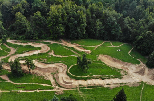 The Pumptrack polygon, set in a natural environment, consists of an undulating track with curves that stretches along the edge of the forest and offers the possibility for recreational cycling.