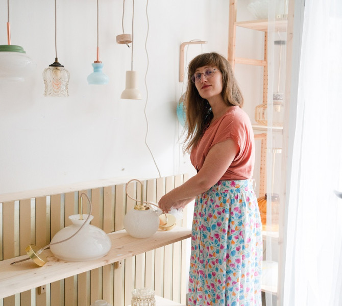 A woman in an apron, making a lamp.