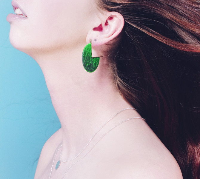 A portrait of a woman with green earrings.