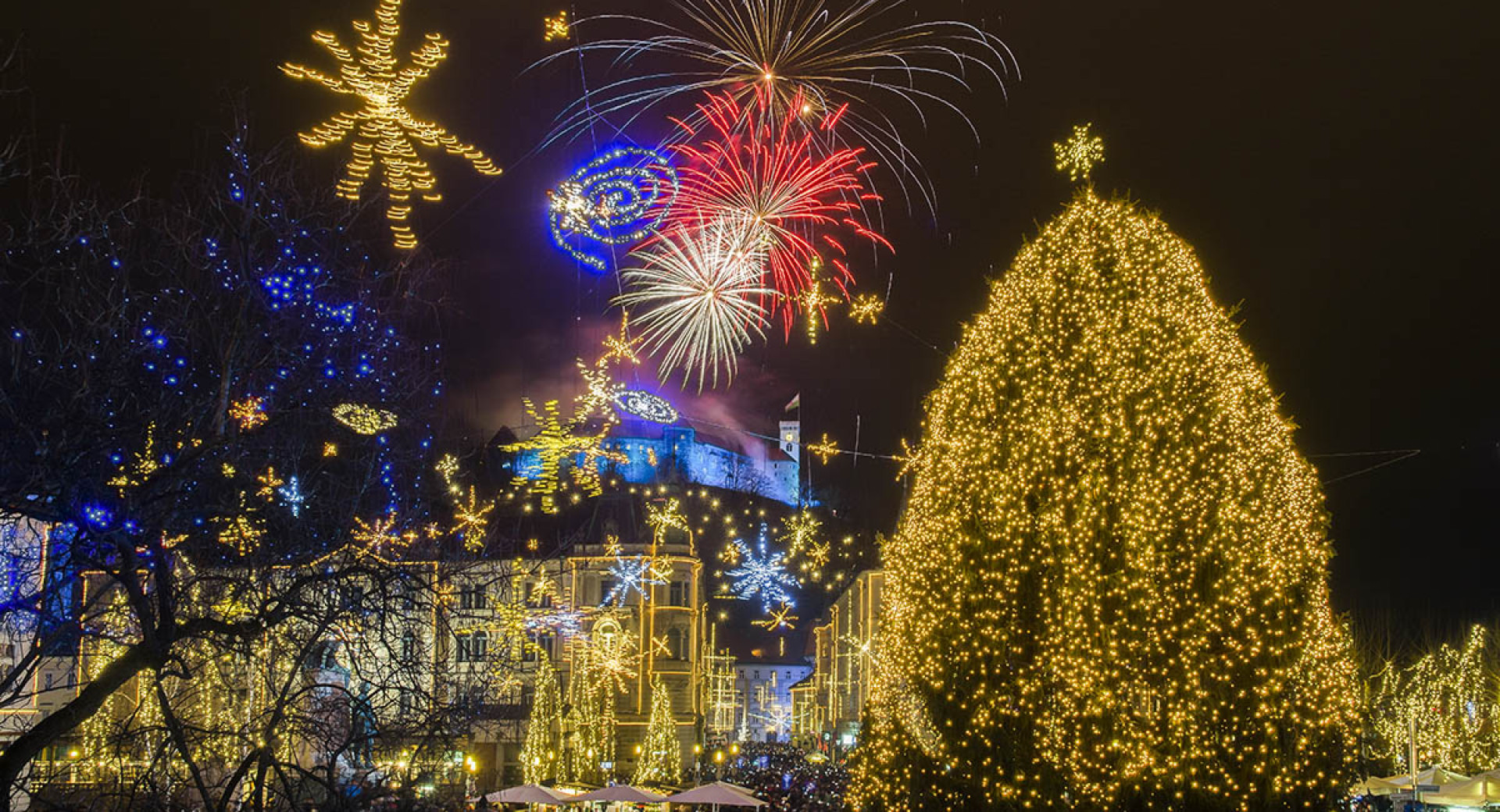 Praznično okrašena Ljubljana. Ognjemet v ozadju.