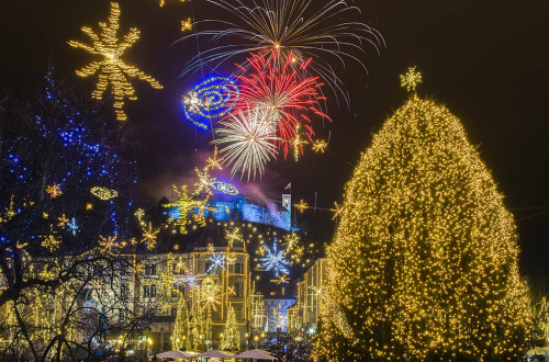 Praznično okrašena Ljubljana. Ognjemet v ozadju.