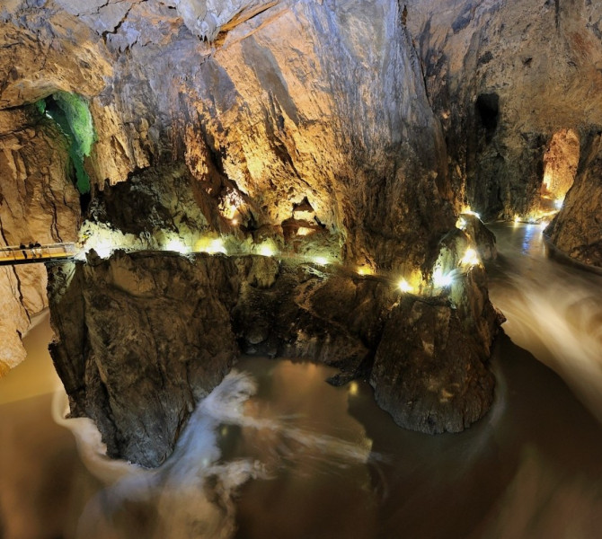 The Reka River, flowing through the Škocjan Caves, with visitors on the bridge.