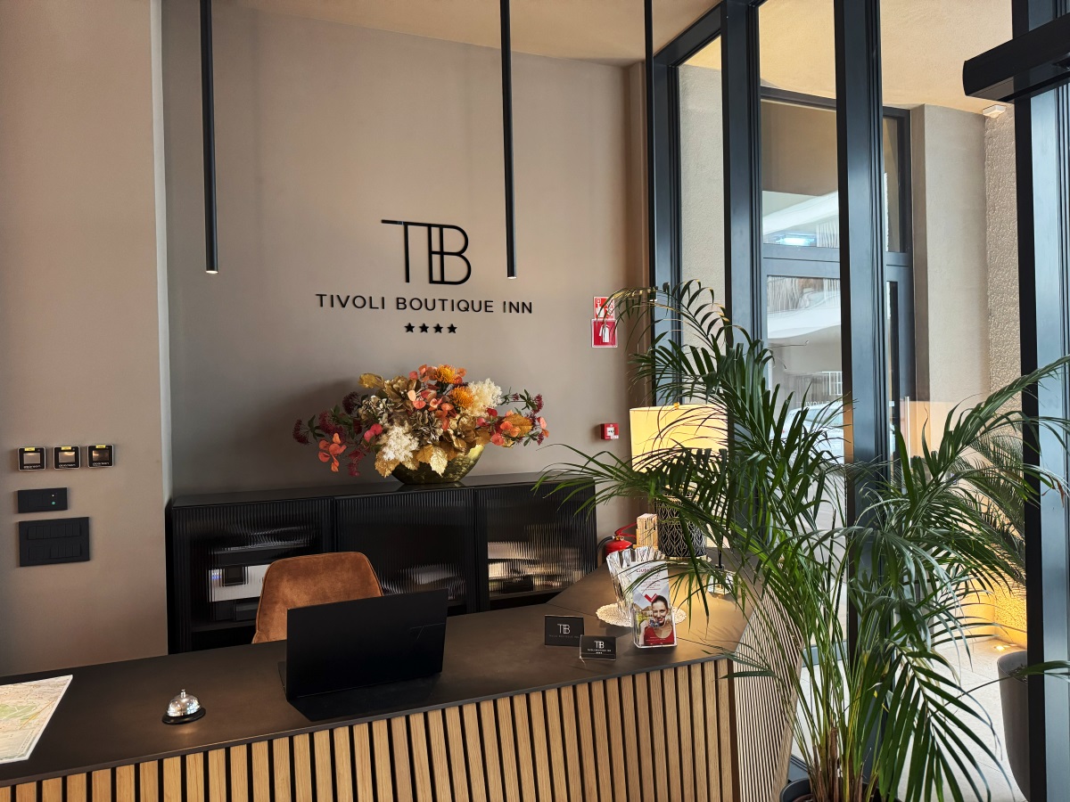 A friendly hotel reception with a modern design, fresh flowers, and a warm atmosphere.
