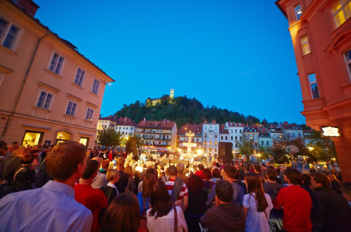 Obiskovalci na prireditvi na Bregu. V ozadju Ljubljanski grad.