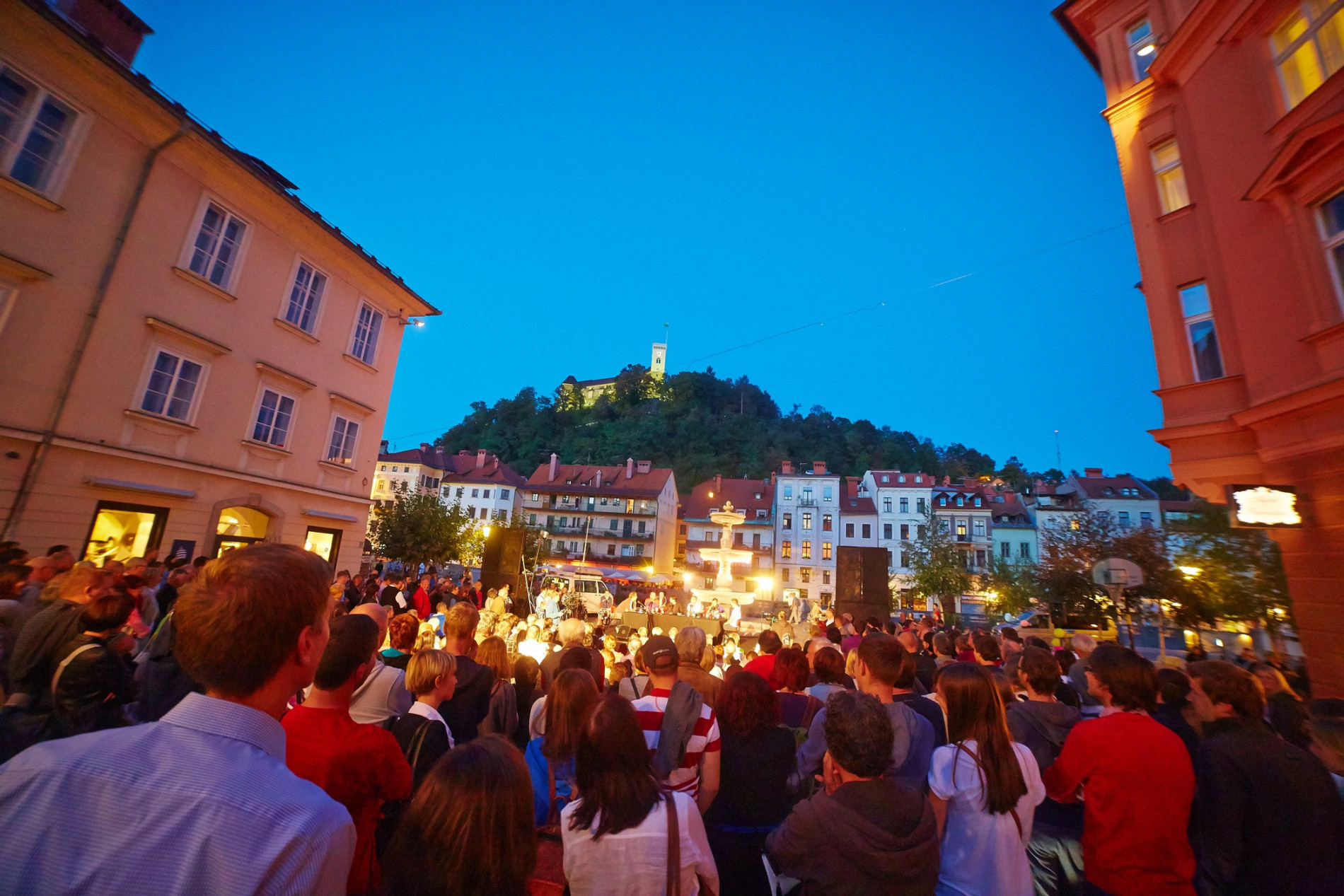 Obiskovalci na prireditvi na Bregu. V ozadju Ljubljanski grad.