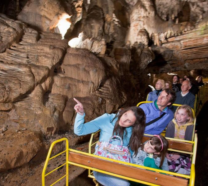 Les gens dans le petit train de la grotte de Postojna