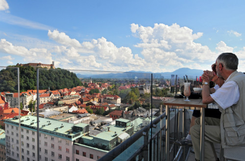 Gostje na Nebotičniku. V ozadju mesto in grad.