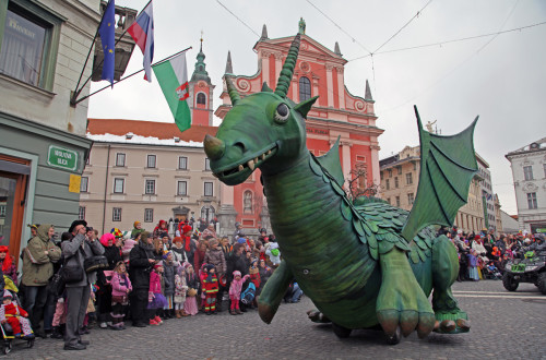 Pustni Ljubljanski zmaj in obiskovalci v ozadju.