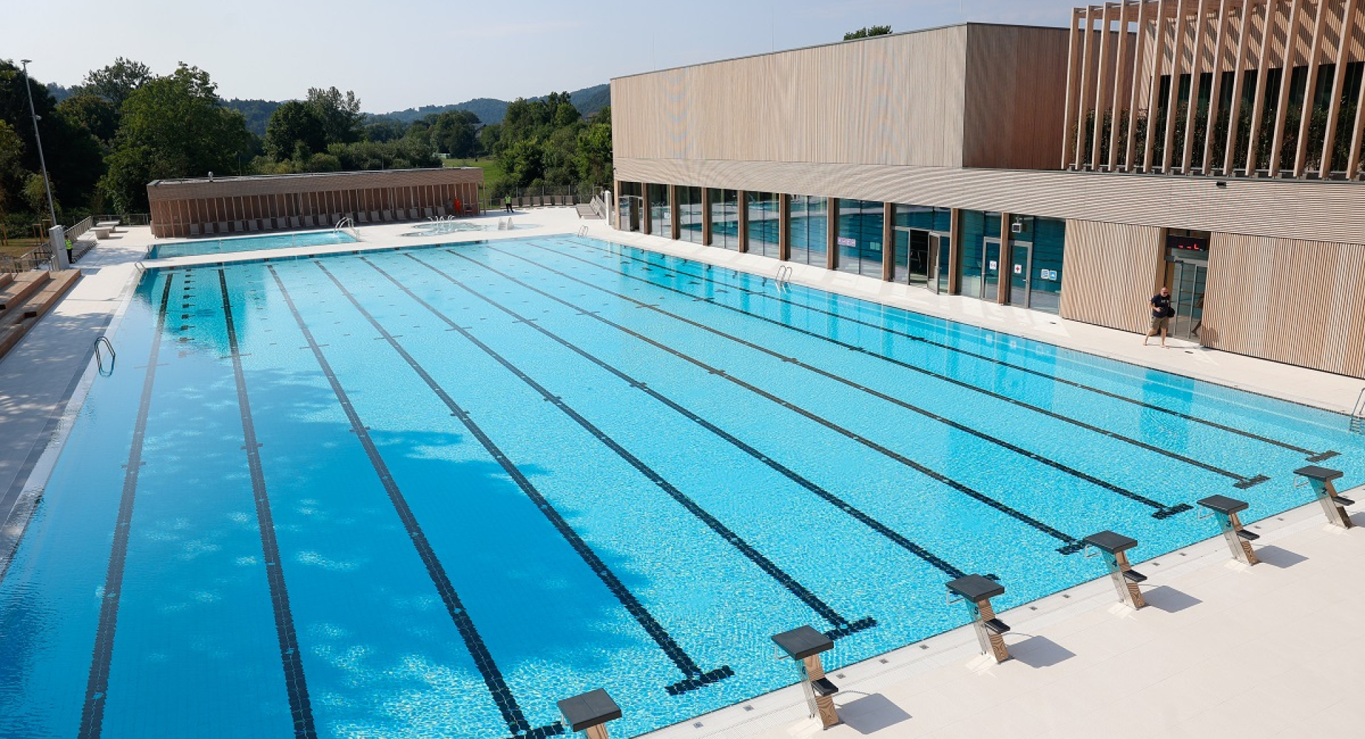 A large outdoor pool with two impressive wooden buildings.