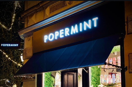 Osvetljena temna izlozba z napisom "Popermint".