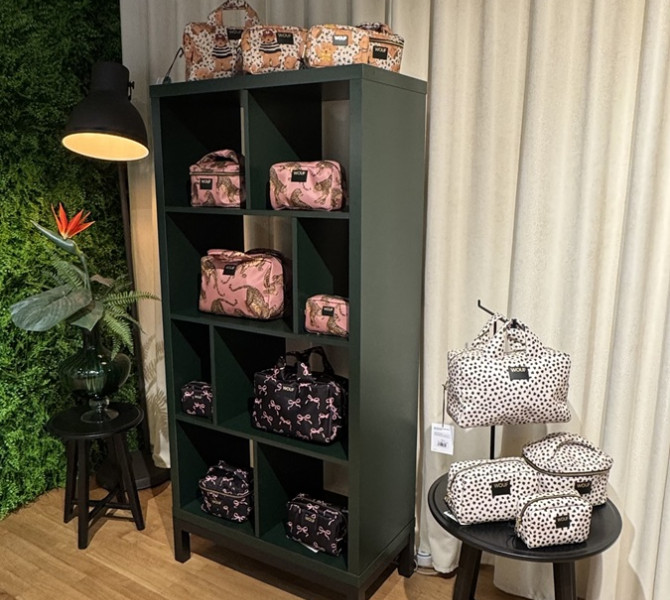 Razlicne velikosti in barve torbic na omari v trgovini.