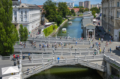 Tromostovje nad Ljubljanico, po kateri plujeta ladjici.