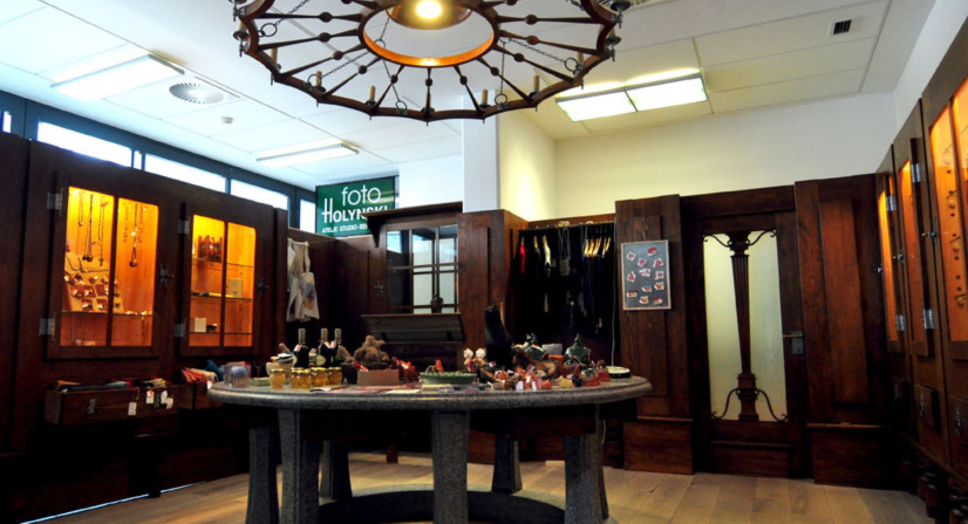 Interior of the shop. A table displaying products stands in the centre. In the background, products are arranged in cabinets.