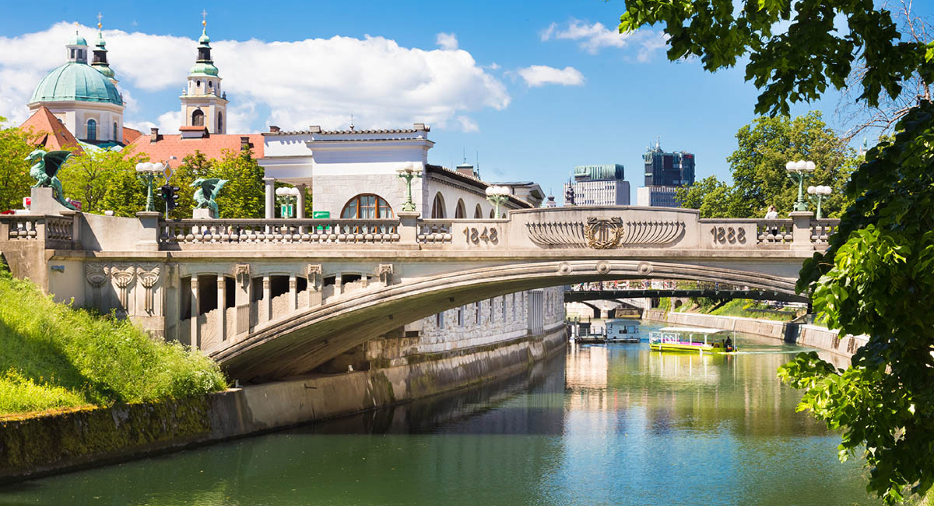 Zmajski most nad Ljubljanico, po kateri plujeta dve ladjici.