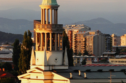 Panoramska slika cerkve s hribi v ozadju.