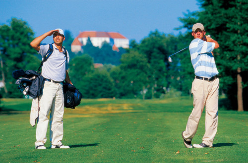 Golfista na igrišču. V ozadju Ptujski grad. 