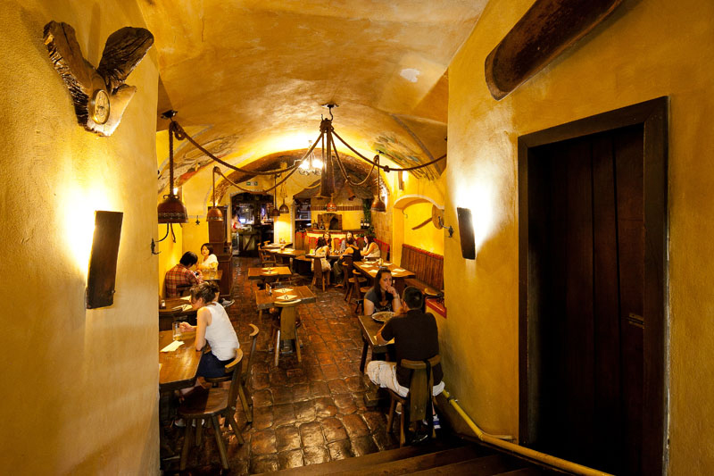 Notranjost lokala z gosti za mizami.