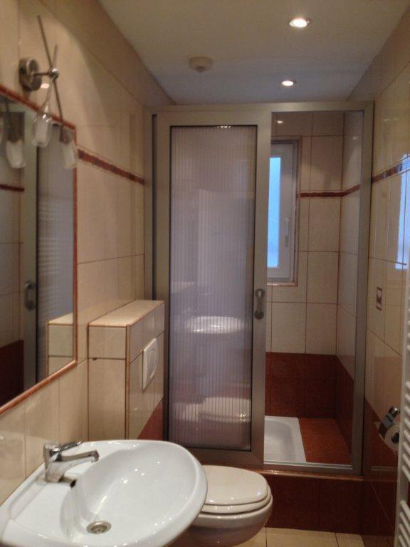 Kopalnica s tuš kabino, WC školjko in umivalnikom. 