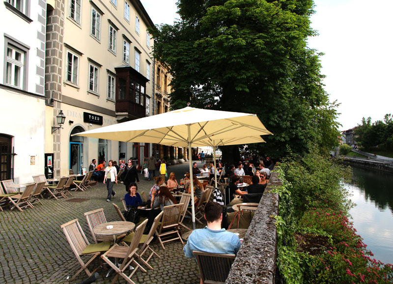 Zunanja terasa pod senčniki, ob Ljubljanici.