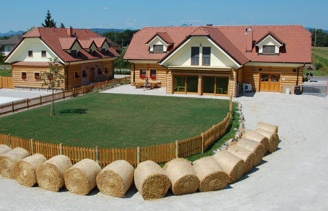The lawn in front of the house, surrounded by bales of hay.