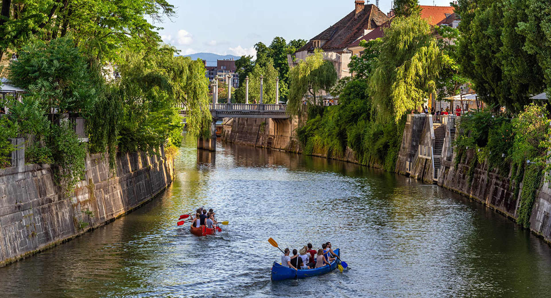 Green experiences: kayaks on the Ljubljanica River, surrounded by greenery.