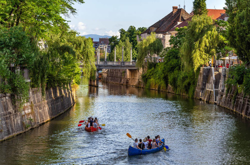 Green experiences: kayaks on the Ljubljanica River, surrounded by greenery.