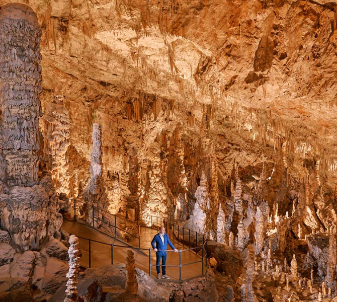 Un visiteur dans une grotte remplie de concrétions.