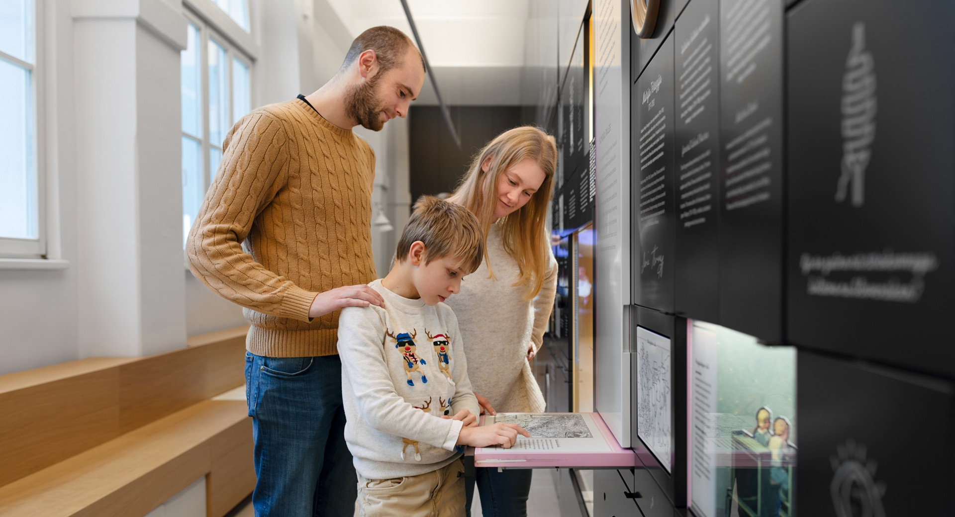 Starsa in sin si ogledujejo interaktivno razstavo v Slovenskem solskem muzeju v Ljubljani.