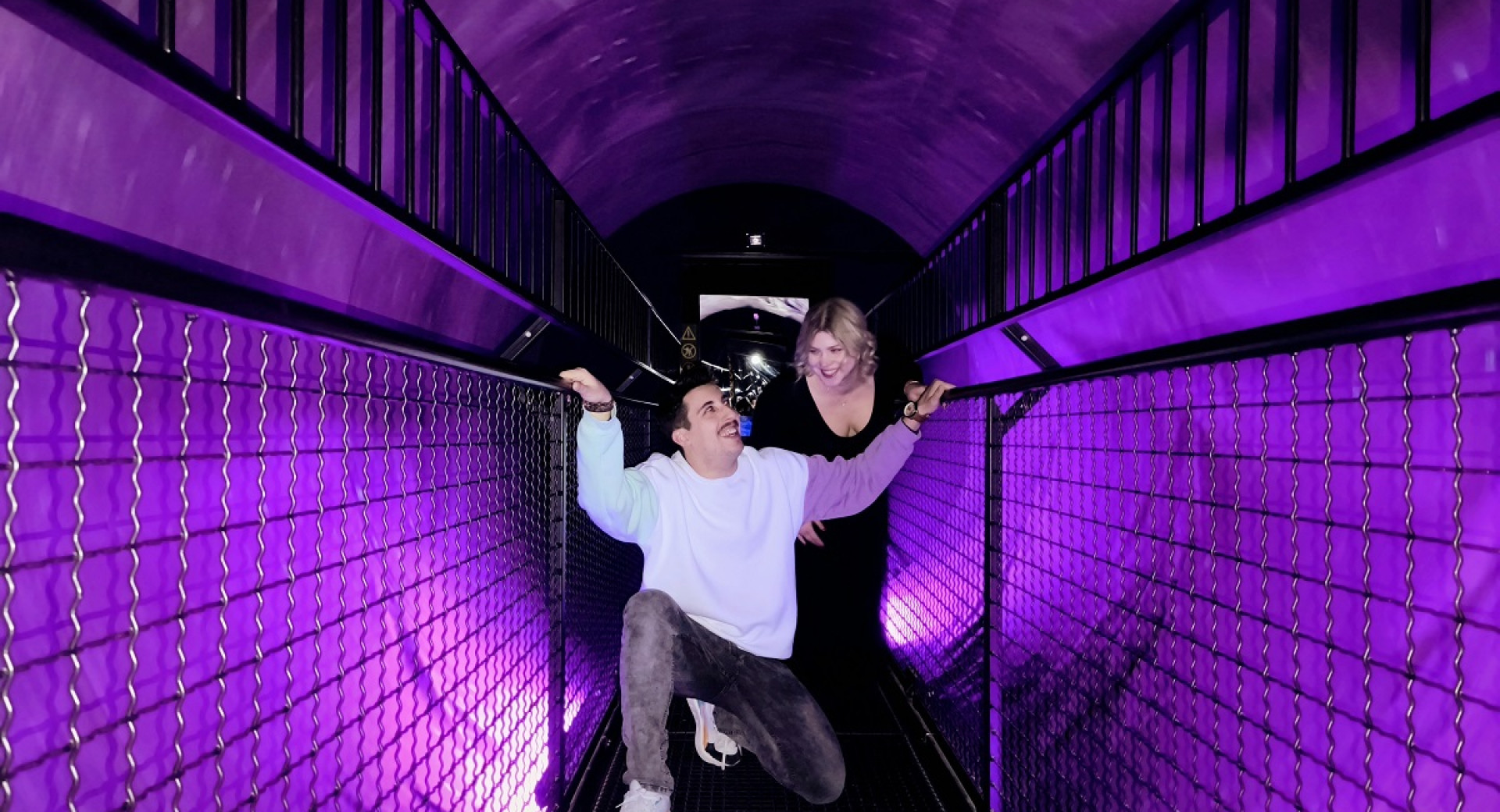 Moski in zenska na mostu v vijolicni sobi.