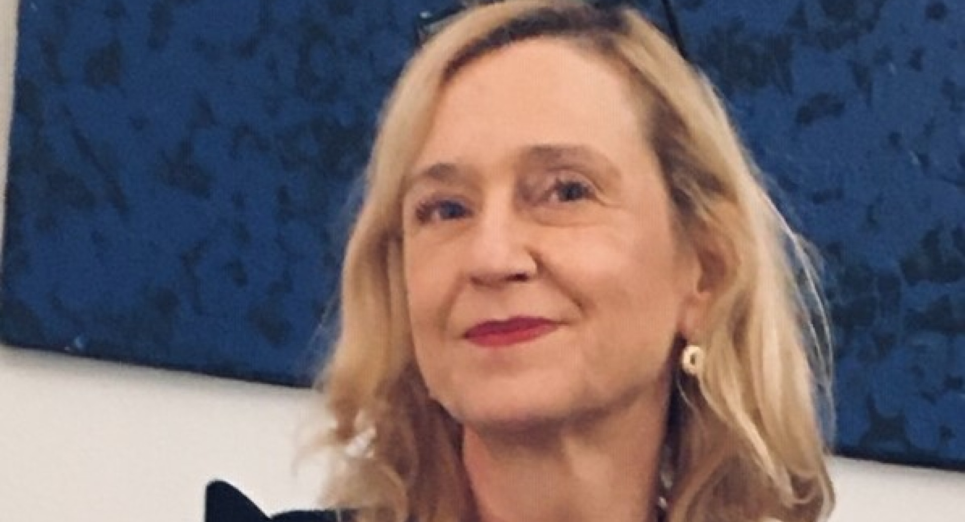 Svetlolasa zenska v crnih oblacilih.