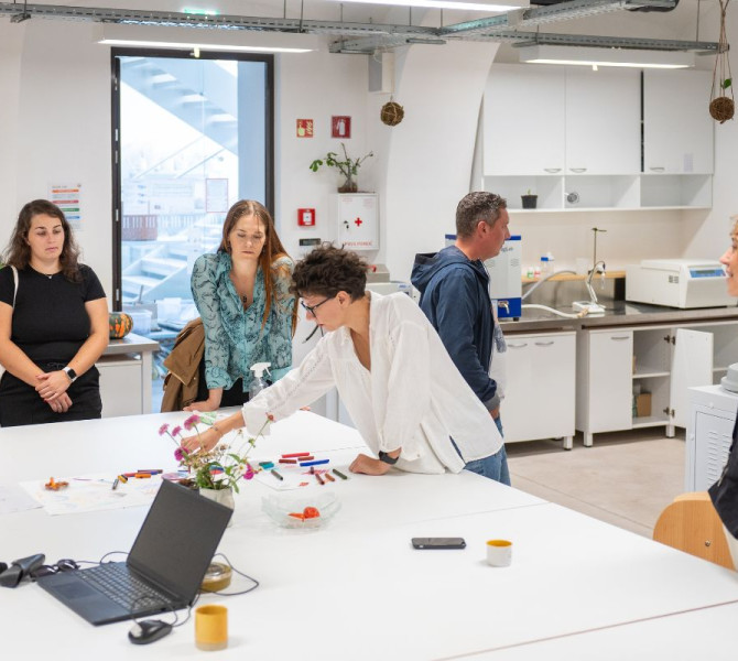 Panoramica dei materiali nel laboratorio di stampa su magliette al Centro Rog. Una donna sta esaminando i materiali.