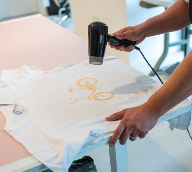 Asciugatura della stampa sulla maglietta con un phon.