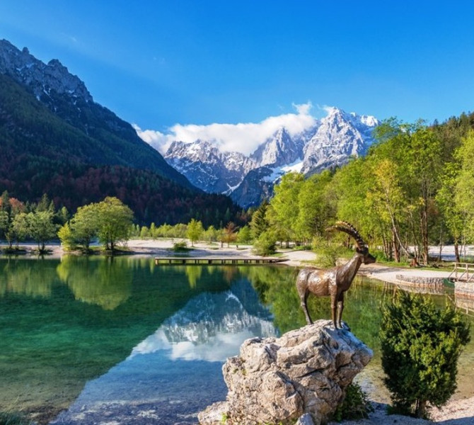 Jezero Jasna in kip kozoroga. V ozadju gore.