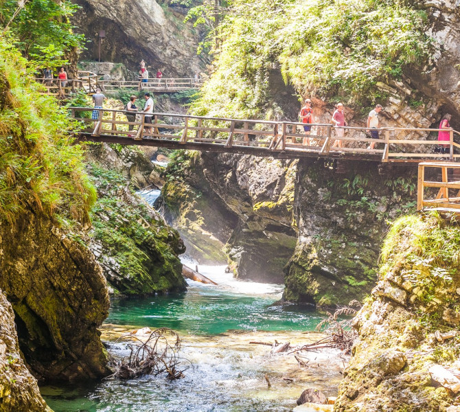 A wooden footbridge over the river in a gorge.