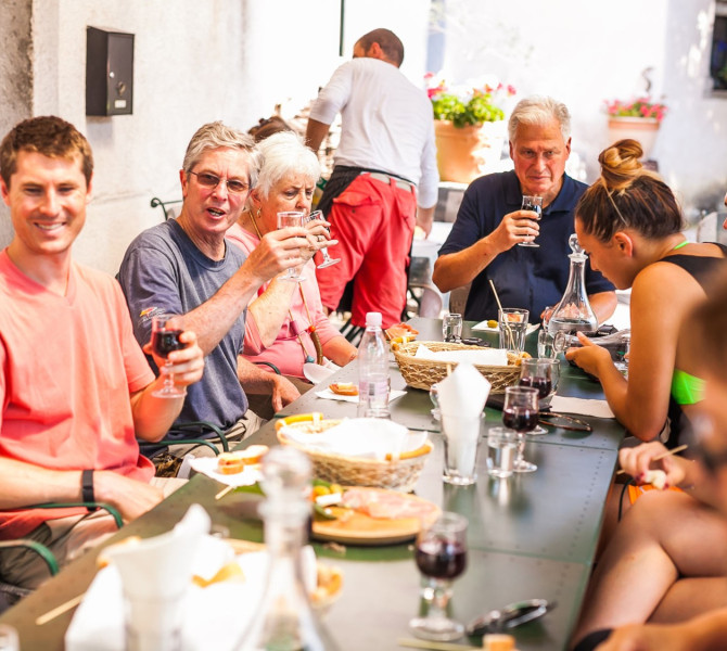 Ljudje sedijo za mizo in jedo.