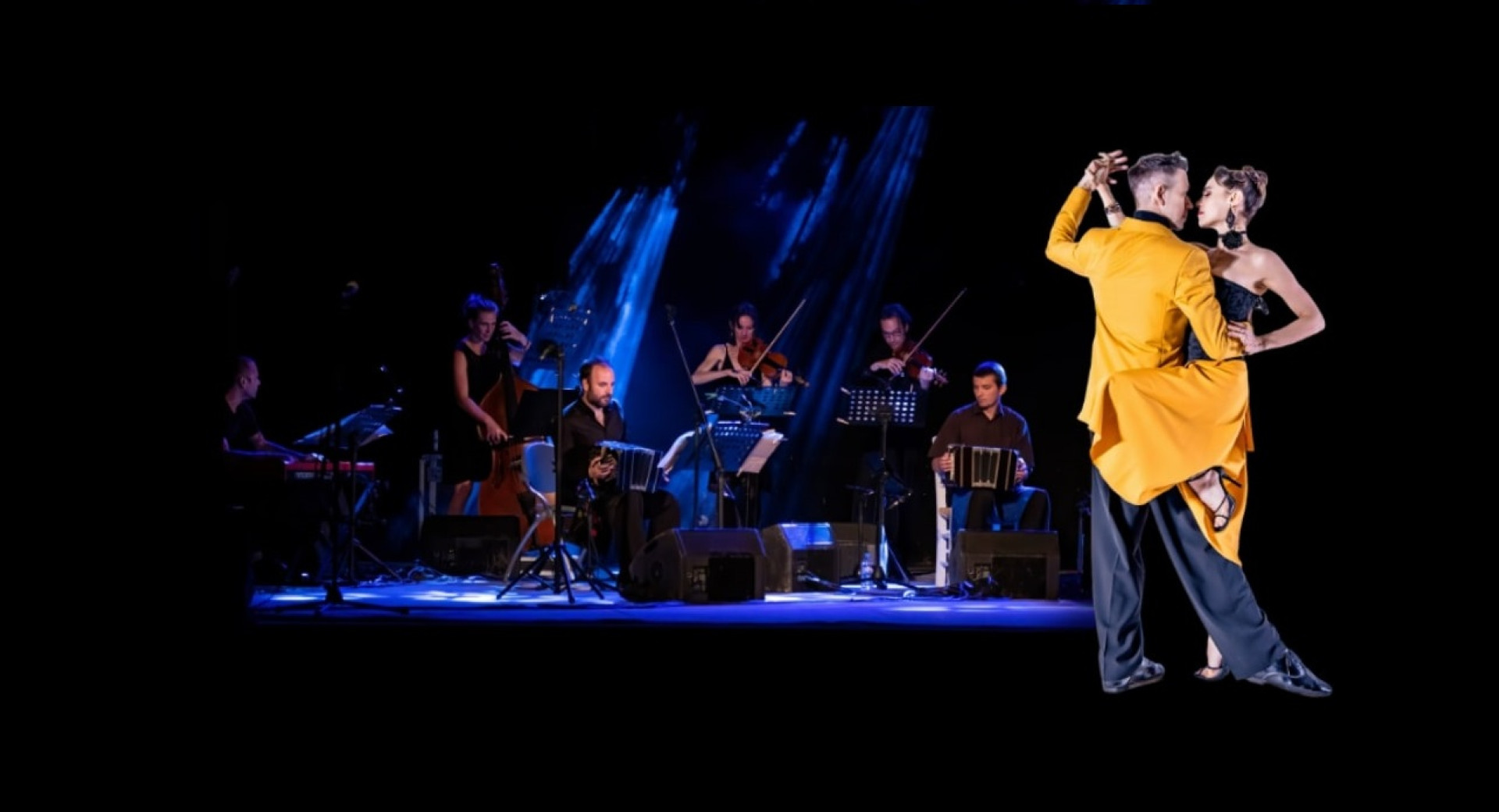 In the foreground, on the right, an illuminated couple dances in an embrace; in the background, on the left, musicians sit and play instruments in the dark under blue spotlights.