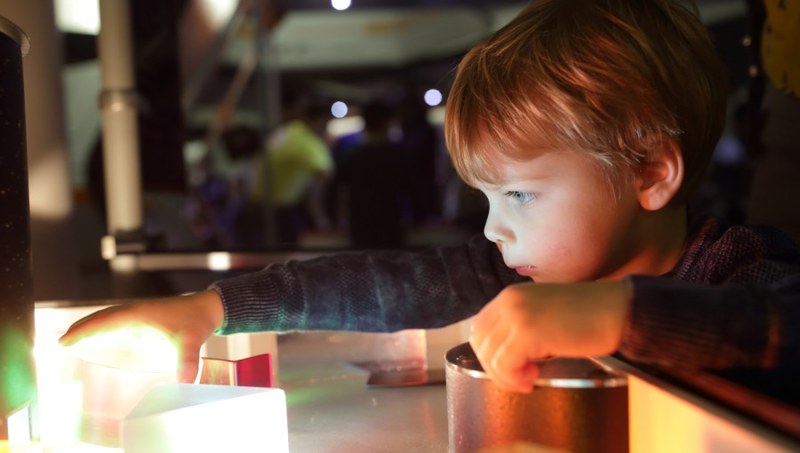 A boy looking in a small lamp.. 