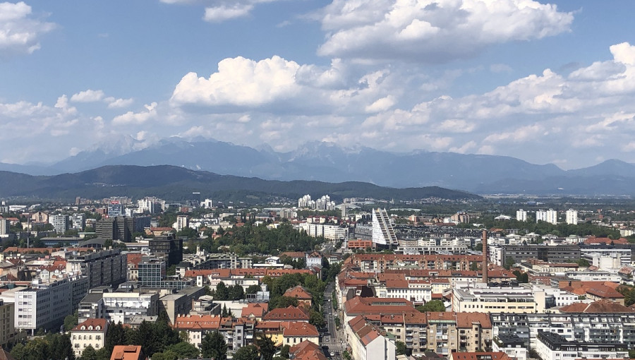 Pogled na mesto z rdecimi hisami in modrim nebom.