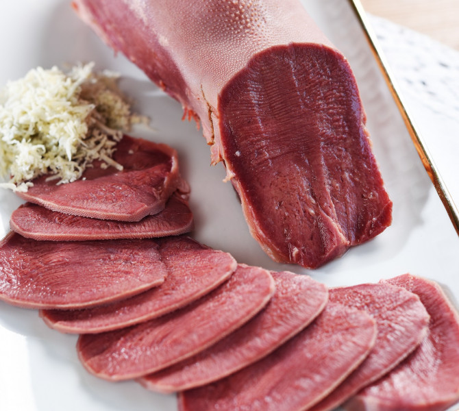 Sliced and cooked beef tongue on a plate.