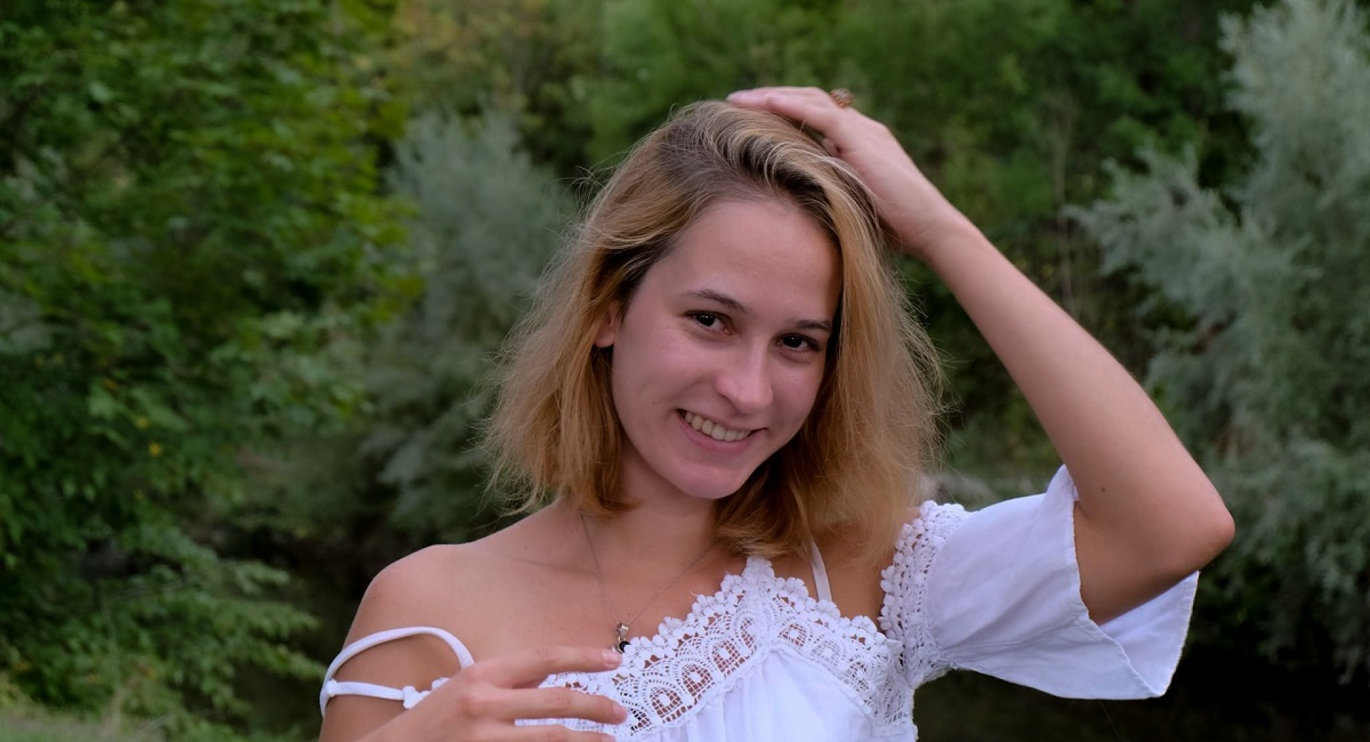 A young smiling woman in a white shirt.