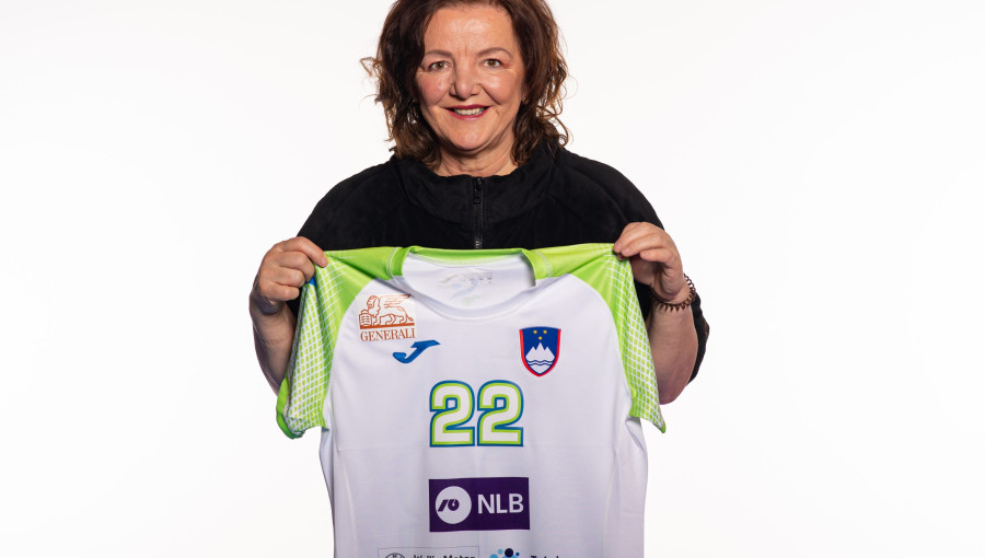 A woman holding a sports uniform.