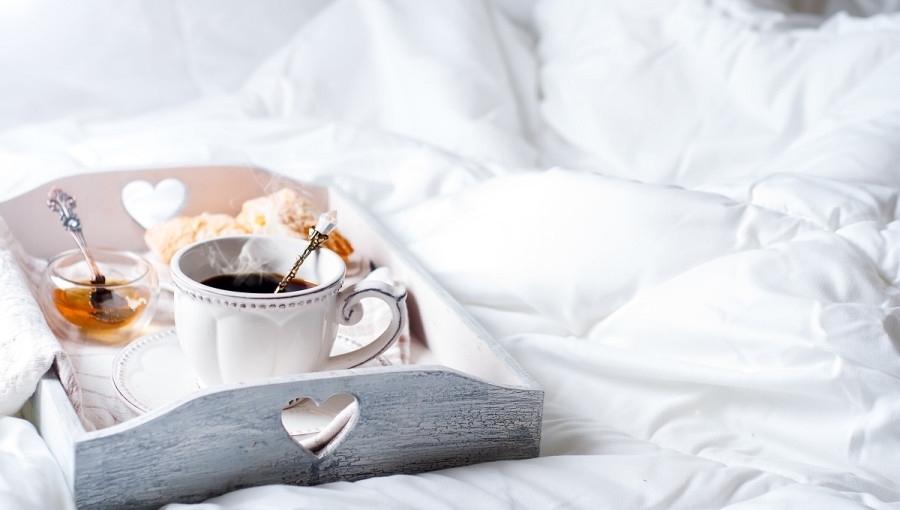 A plater on a white bedding. Fresh coffee and honey on it.