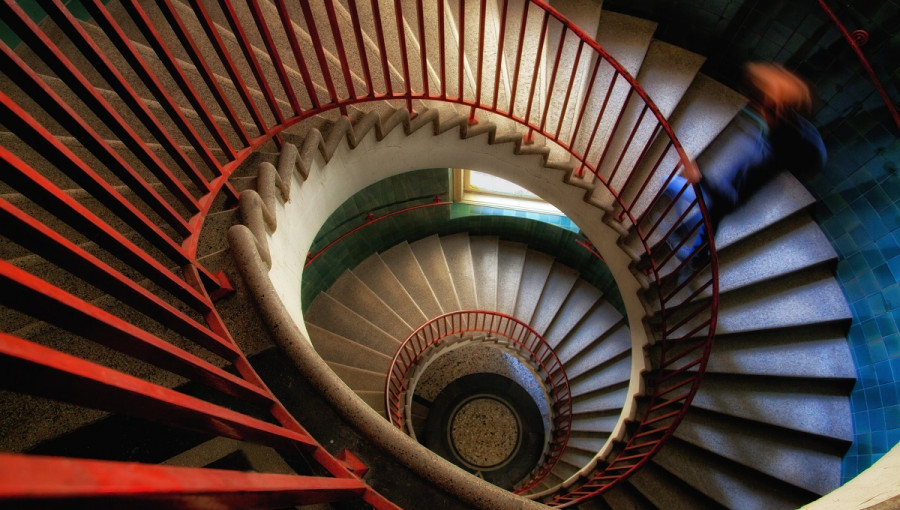 Very long snail staircase with a red fence.