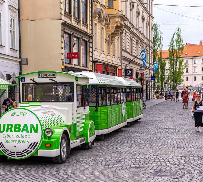 Zeleno-beli električni vlakec namenjen ogledu mesta.