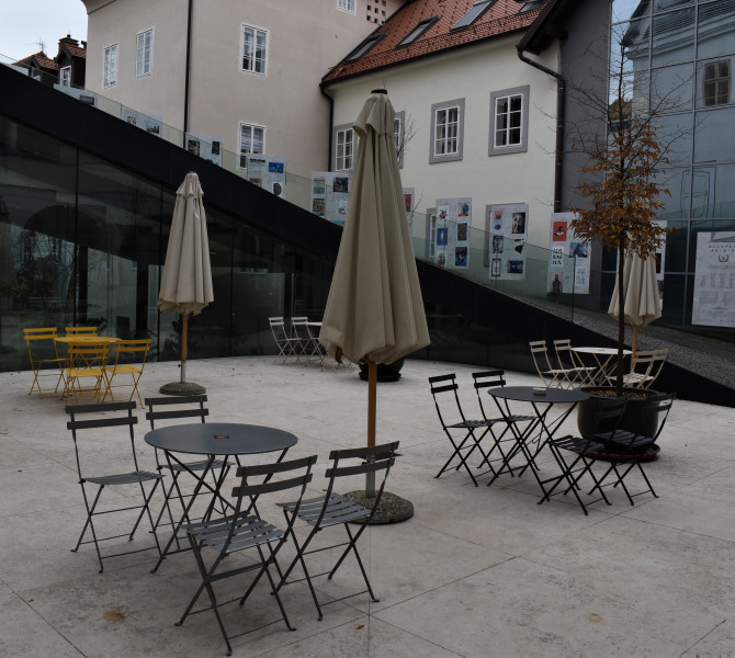 A large concrete yard with chairs and tables.